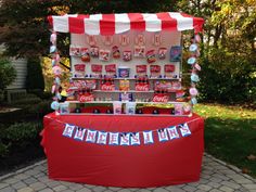 an ice cream stand is decorated with red and white striped awnings, candy bar signs, and bunting streamers