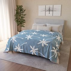 a bed with blue and white bedspread in a bedroom next to a window