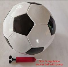 a soccer ball sitting on top of a table next to a red and black marker