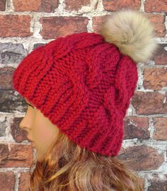 a woman wearing a red hat with a white pom - pom on top