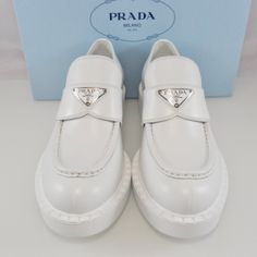 Nib$1200 Prada Spazzolato Logo Platform Leather Loafers Size: 39 Made In Italy Brand New With Original Box! 100% Authentic! Current Model! Crafted Of Smooth Spazzolato Leather, These Loafers From Prada Feature The Label's Logo On The Vamp, A Notched Welt Pattern, And A Platform Rubber Sole. Leather Upper With Leather Strap Enameled Metal Triangle Logo Round Toe Slip-On Style 50 Mm Rubber Monobloc Sole With Hot-Stamped Logo Notched-Effect Stamped Rubber Welt Stacked Block Heel, 2" (50mm) Brand Ne Luxury White Pointed Toe Loafers, Luxury Patent Leather Loafers With Round Toe, Designer Calf Leather Loafers With Removable Insole, Designer Calf Leather Slip-on Loafers, Luxury White Flat Heel Loafers, Formal Low-top Calf Leather Loafers, Luxury White Almond Toe Loafers, Luxury Loafers With Branded Insole And Pointed Toe, Luxury Pointed Toe Loafers With Branded Insole