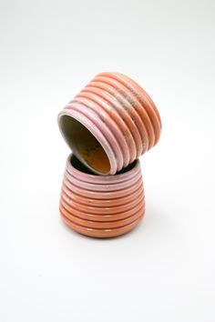 an orange and pink vase sitting on top of a white table