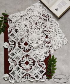 an open book and some white doily on a table