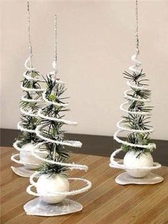 three white christmas trees with ornaments on them