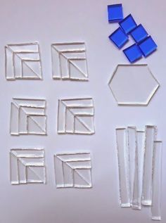 several pieces of glass sitting next to each other on a white surface with blue squares