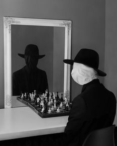 a person wearing a mask playing chess in front of a mirror