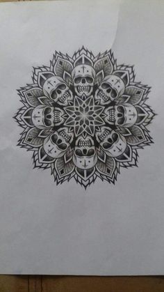 a piece of paper with a drawing of skulls on it and an intricate design in the middle