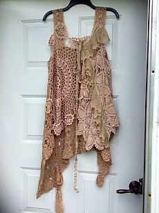 a crocheted top hanging on a door