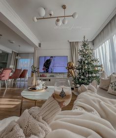 a person holding a glass of wine in front of a tv with a christmas tree on it