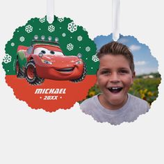 a young boy is smiling and wearing a birthday ornament with cars on it