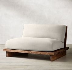 a white couch sitting on top of a wooden frame