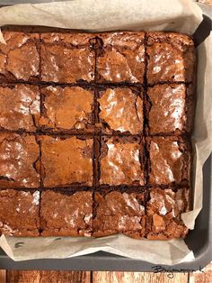 a pan filled with brownies sitting on top of a wooden table