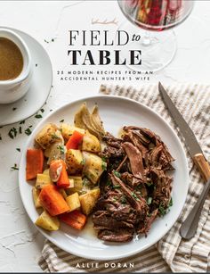 a white plate topped with roast, potatoes and carrots next to a glass of wine