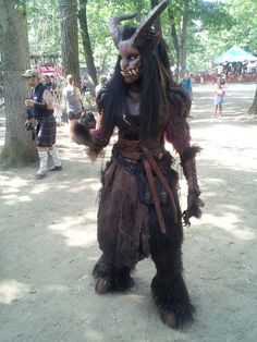 a man dressed as a demon in the woods