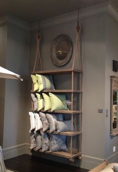 a living room filled with lots of furniture and pillows on top of a wooden shelf