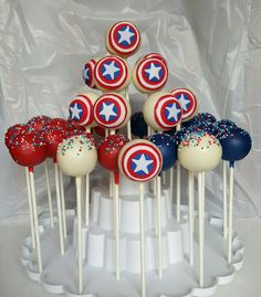 the cake pops are decorated with red, white and blue sprinkles as well as captain america's shield