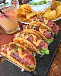 some tacos and chips are sitting on a tray