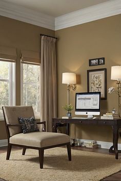 a living room with a chair, desk and computer on the table in front of two windows