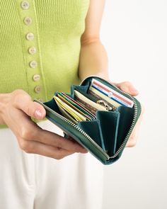 a woman is holding her wallet open and showing it's empty card holders inside