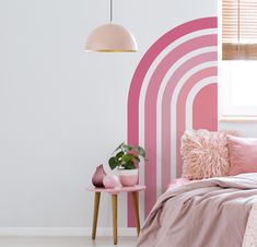 a bedroom with pink and white stripes painted on the walls, bedding and pillows