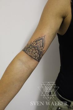 a woman's arm with a tattoo on it and an intricate design in the middle