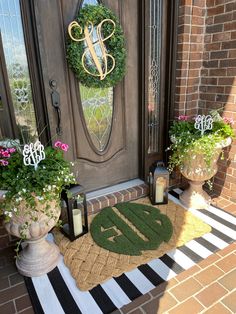 the front door is decorated with two wreaths and three candles, one for each letter