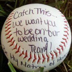 a baseball sitting in the grass with some writing on it's side and words written on its outside