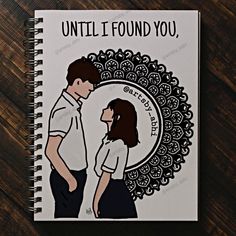 a spiral notebook with an illustration of a man and woman facing each other on a wooden surface