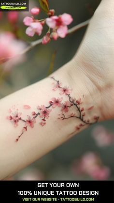 a woman's arm with pink flowers on it and the words get your own 100 % unique tattoo design