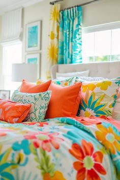 a bed with bright colored pillows and colorful comforter on top of it, in front of a window