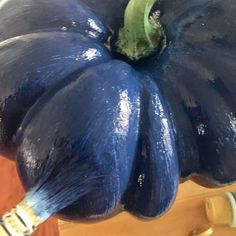 a blue pumpkin sitting on top of a wooden table