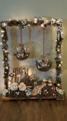 a wooden table topped with candles and flowers on top of a wall covered in lights