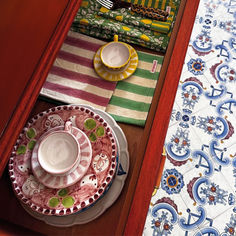 the table is set with colorful dishes and placemats, along with napkins