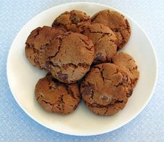 a plate full of chocolate chip cookies on a blue and white tableclothed surface