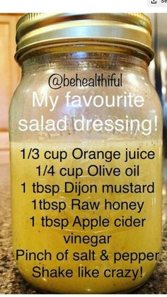 a jar filled with orange juice sitting on top of a counter