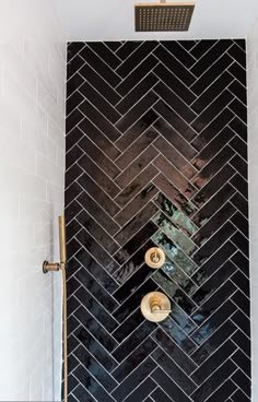 a bathroom shower with black and white herringbone tile