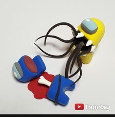 two plastic toys are sitting on a white surface with a black cord attached to them