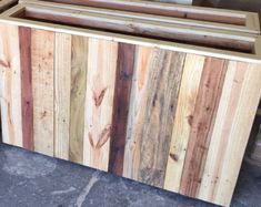 a wooden box sitting on top of a floor next to other wood boxes and pallets