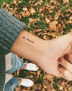 a person's arm with a small tattoo that says love on the left wrist