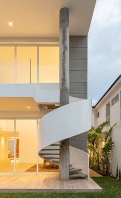 a spiral staircase in front of a modern house