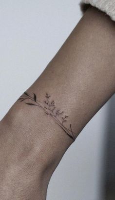 a woman's arm with a tattoo on it that has flowers growing out of it