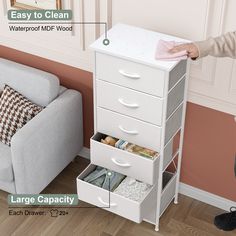 a woman standing next to a white cabinet with drawers