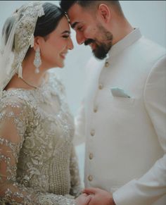 a bride and groom smile at each other