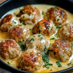 some meatballs are covered in gravy and garnished with parsley