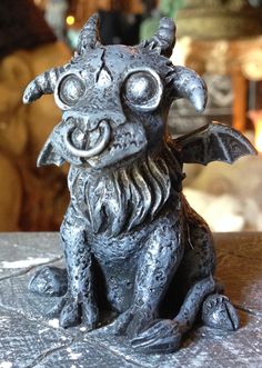 a statue of a demon sitting on top of a table