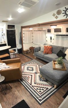 a living room with couches, chairs and rugs on the hardwood flooring