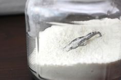 a jar filled with white powder sitting on top of a wooden table