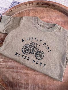 Adorable Tractor Tee for your little one. If you babe loves to play in the dirt this one is for you. A little dirt never hurt is printed in black around a tractor. Size Options are - 2T, 3T, 4T, 5T, Youth S, M, L and XL Runs True to size. Toddler shirts are 100% Cotton. Youth Shirts are 50% Cotton, 25% Polyester and 25% Rayon. There is a slight color difference between Toddler and Youth tees. Looking for more Graphic Tees? Click here ---> https://www.etsy.com/shop/GingerAndBabe?ref=seller-platfo Three Tractor Shirt, Toddler Boy Shirts Vinyl Farm, Cute Cricut Shirts Farm, Farming Birthday Party, Farm Birthday Shirt, Kids Shirts Design, Farmer Shirt, Cute Shirt Designs, Grandpa Shirt