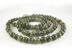 "-The genuine green nephrite jade gemstones in this necklace display a gorgeous blend of light and dark greens. Pretty antiqued gold beads look lovely next to the jade and provide just the right accent. Long enough to wear doubled, no matter how you wear it, this stunning jade necklace will look beautiful on you! * About jade: There are only two types of genuine jade, nephrite (like this necklace) and jadeite. Other types of \"jade\" like Malaysia jade, mountain jade, China jade, African jade, c Green Jade Necklace With 108 Beads, Green Jade Beaded Necklace For Meditation, Jade Mountain, Jade Bead Necklace, Jade Gemstone, Nephrite Jade, Necklace Display, Necklace Green, Jade Necklace