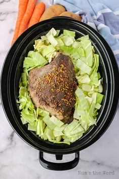 a bowl filled with meat, lettuce and carrots on top of a table